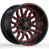 Two black and red milled off-road truck tires with the brand name 'Revenge' visible, positioned upright.